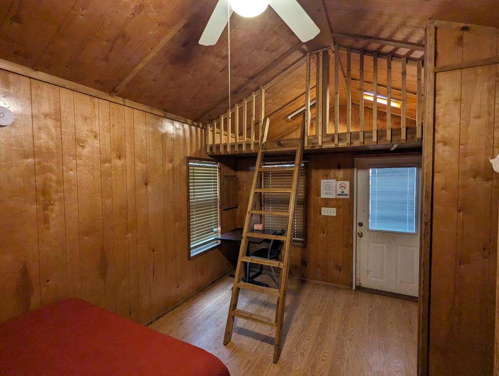 A ladder to a loft near inside a camping cabin